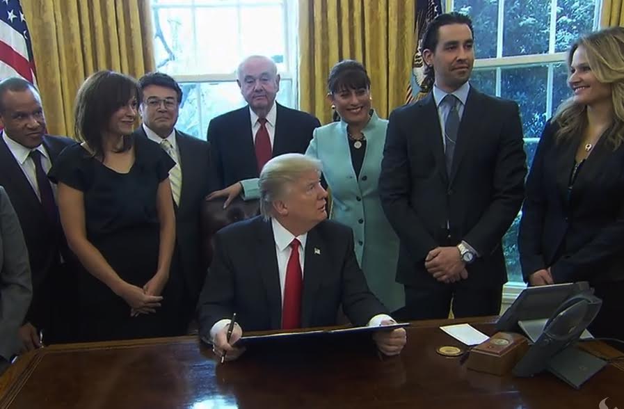 President Trump signs the executive order surrounded by small business leaders, including Florida SBDC Network Advisory Board Member Dennis Bradford (pictured back row in center).